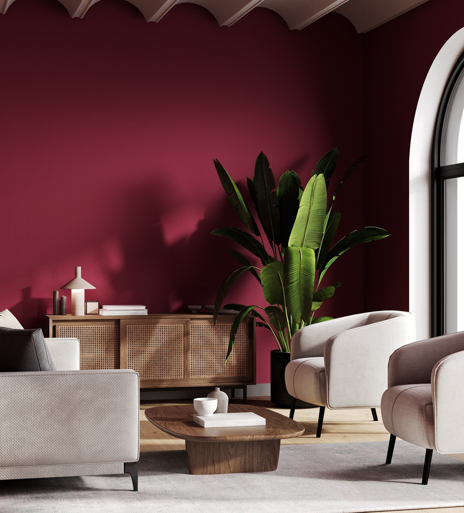 A refreshed living room with deep red walls, a rattan sideboard and cream armchairs